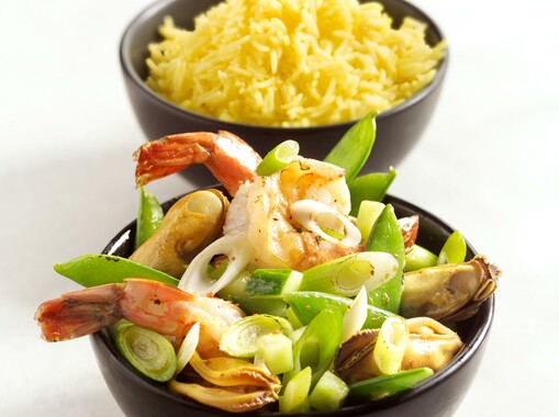 Roerbak van garnalen en mosselen met gele rijst